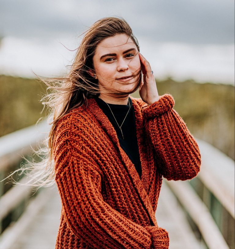 Woman with a red sweater standing in the wind